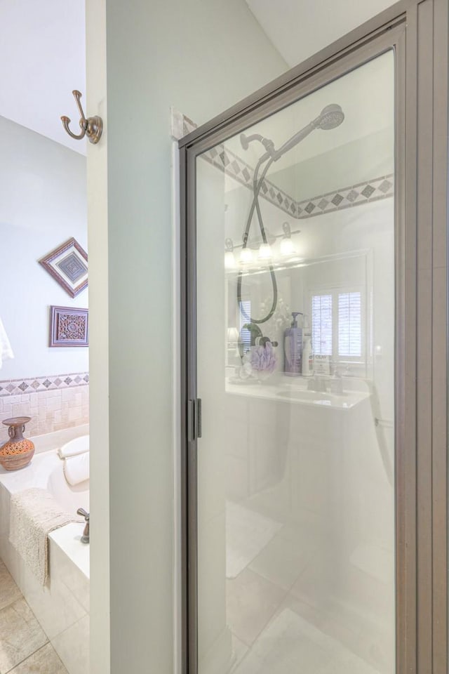 bathroom featuring tile patterned flooring and shower with separate bathtub