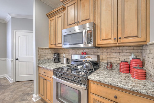 kitchen featuring light stone counters, ornamental molding, appliances with stainless steel finishes, and tasteful backsplash