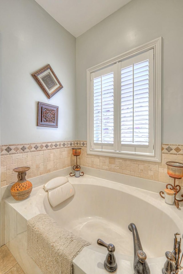 bathroom featuring tile patterned floors and a bath