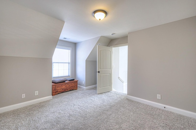 bonus room with vaulted ceiling and light carpet