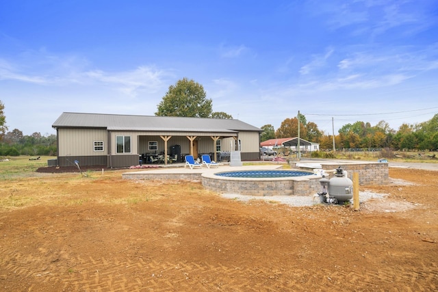 rear view of property featuring a hot tub and a patio