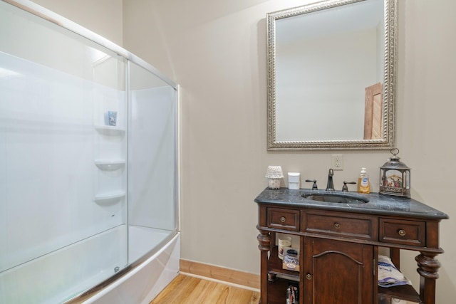 bathroom with washtub / shower combination, vanity, and hardwood / wood-style floors