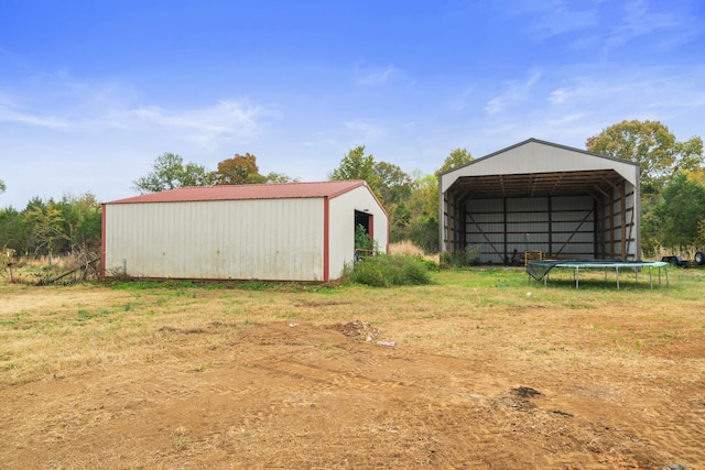 view of outdoor structure featuring a trampoline and a yard