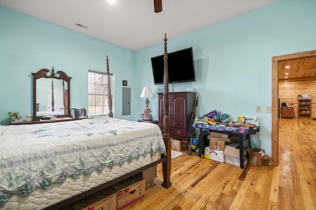 bedroom featuring ceiling fan, electric panel, and light wood-type flooring