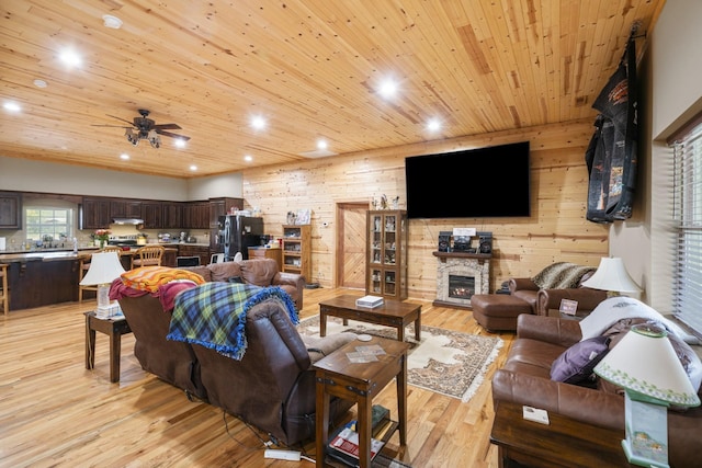 living room with wood ceiling, a fireplace, wooden walls, and light wood-type flooring