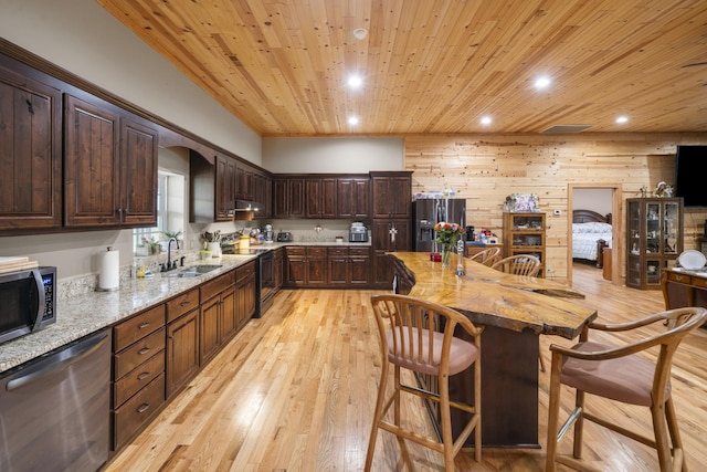 kitchen featuring sink, appliances with stainless steel finishes, wooden walls, wooden ceiling, and light wood-type flooring