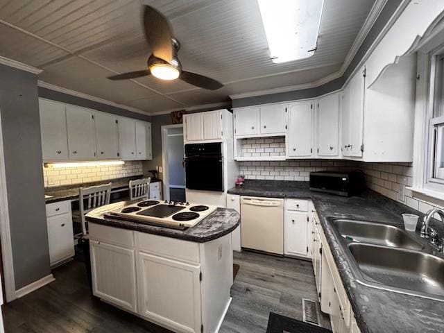 kitchen with white appliances, a kitchen island, and white cabinets