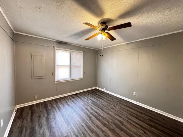 spare room with crown molding, dark hardwood / wood-style floors, and a textured ceiling