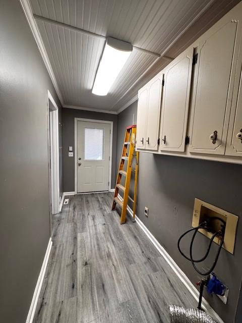 laundry room featuring hookup for a washing machine, ornamental molding, cabinets, and light hardwood / wood-style floors