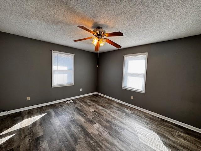 unfurnished room with dark wood-type flooring, ceiling fan, and a textured ceiling