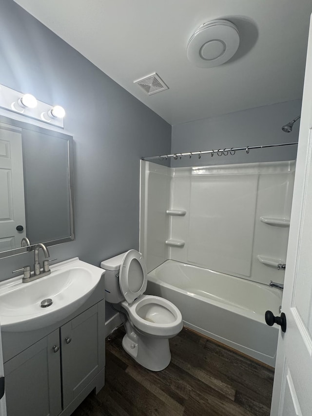 bathroom with visible vents, wood finished floors, vanity, toilet, and bathing tub / shower combination