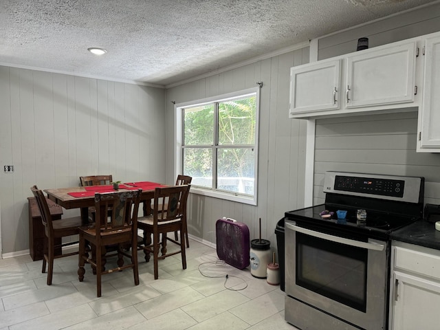 tiled dining area with a textured ceiling and wooden walls