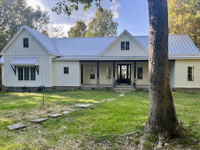 modern farmhouse style home with covered porch and a front lawn