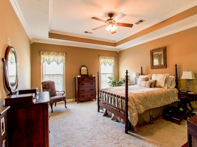 carpeted bedroom with ceiling fan, ornamental molding, a raised ceiling, and multiple windows