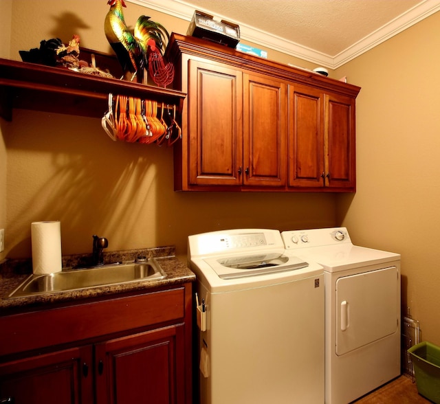 laundry room featuring sink, ornamental molding, cabinets, and independent washer and dryer