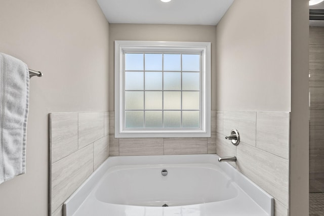 bathroom with a bath and tile walls