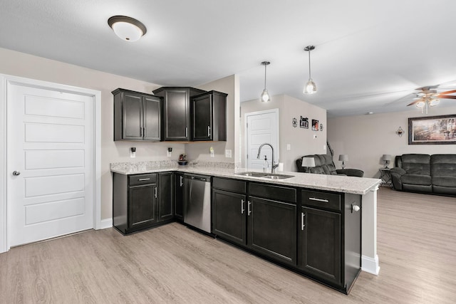 kitchen featuring hanging light fixtures, light hardwood / wood-style flooring, stainless steel dishwasher, and sink