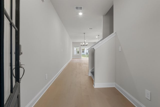 corridor featuring a chandelier and light wood-type flooring