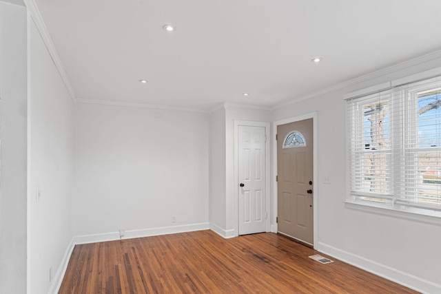 foyer entrance with ornamental molding and wood-type flooring