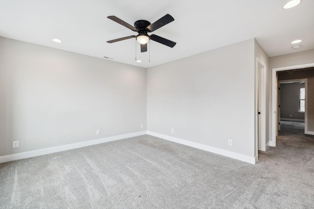 unfurnished room with light colored carpet and ceiling fan