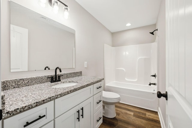 full bathroom with vanity, hardwood / wood-style floors, shower / tub combination, and toilet