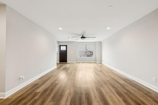 unfurnished living room with ceiling fan and wood-type flooring