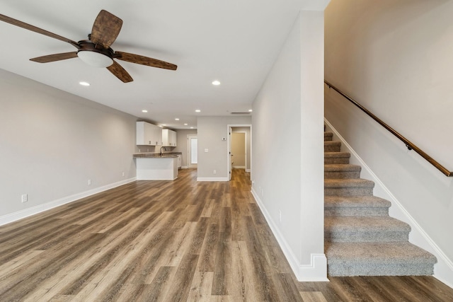 unfurnished living room with ceiling fan and wood-type flooring