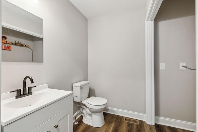 bathroom with vanity, wood-type flooring, and toilet