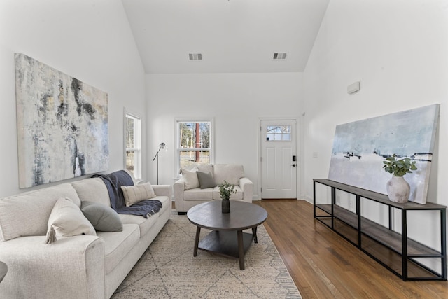 living room with hardwood / wood-style floors and high vaulted ceiling