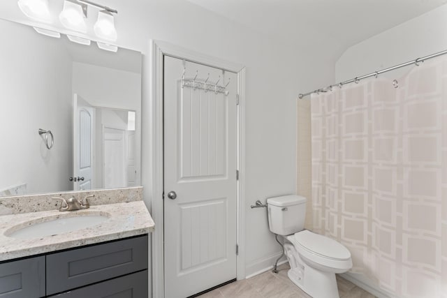 bathroom featuring tile patterned flooring, vanity, lofted ceiling, and toilet