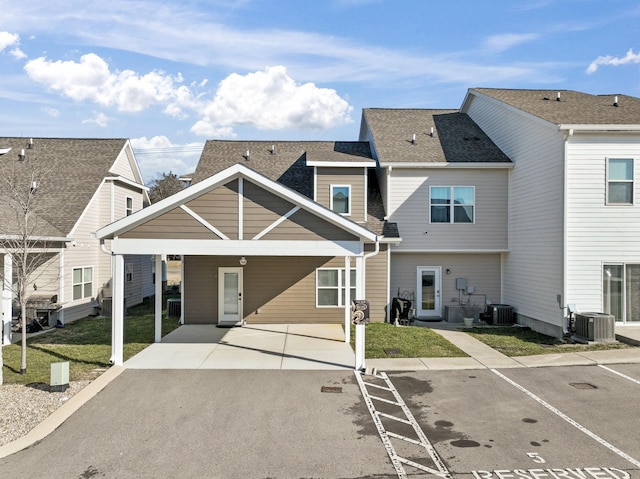 view of front facade with a carport, central AC unit, and a front lawn