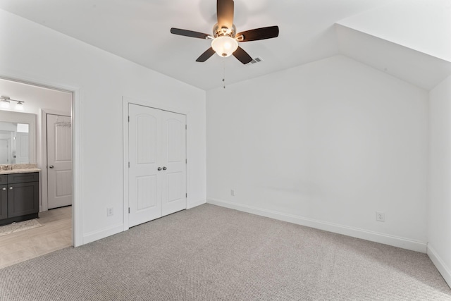 unfurnished bedroom with light carpet, connected bathroom, and ceiling fan