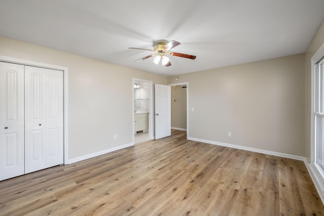 unfurnished bedroom with a closet, ceiling fan, light hardwood / wood-style floors, and ensuite bath