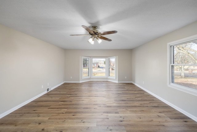 unfurnished room with hardwood / wood-style floors, a textured ceiling, and ceiling fan