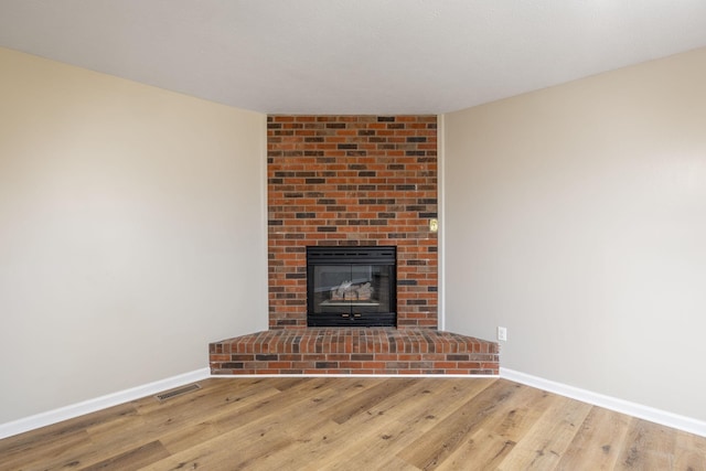 unfurnished living room featuring light hardwood / wood-style flooring and a fireplace