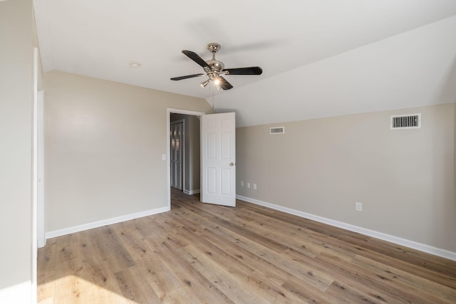 unfurnished room with ceiling fan, vaulted ceiling, and light wood-type flooring