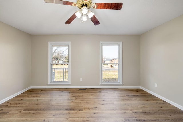 empty room with ceiling fan and light hardwood / wood-style flooring