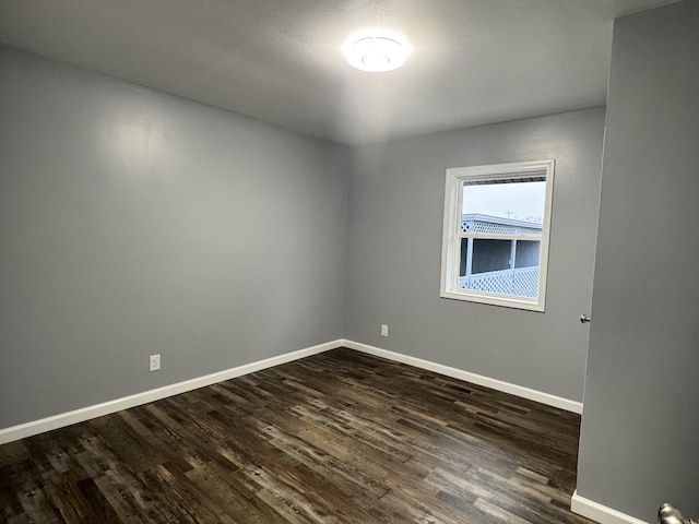 empty room with dark hardwood / wood-style floors