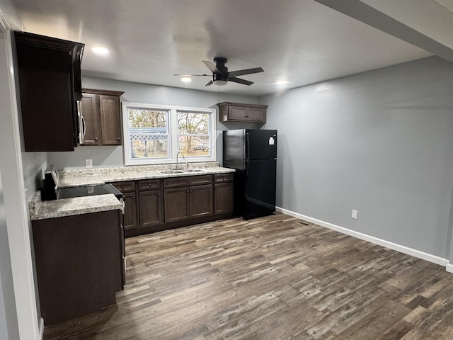 kitchen featuring electric stove, black fridge, sink, and light hardwood / wood-style flooring