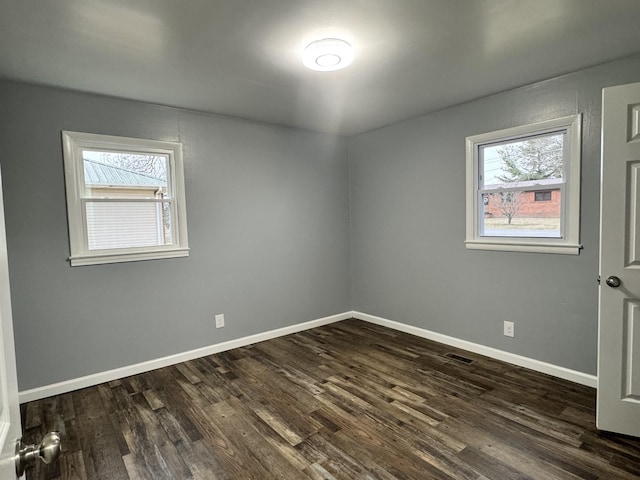 empty room with dark hardwood / wood-style flooring