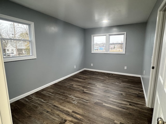 unfurnished room featuring dark wood-type flooring and plenty of natural light