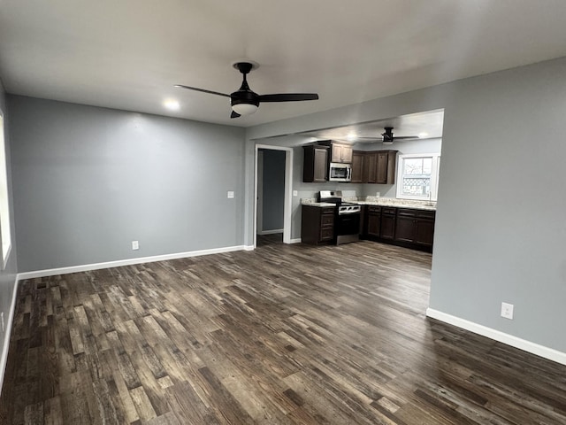 kitchen with dark wood-type flooring, ceiling fan, appliances with stainless steel finishes, and dark brown cabinets