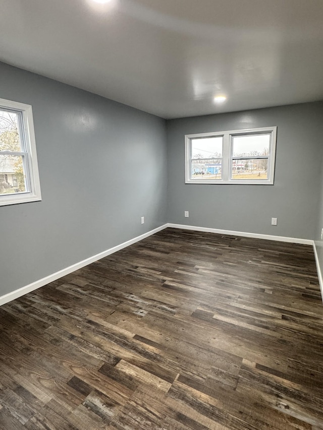 unfurnished room with dark wood-type flooring and a wealth of natural light