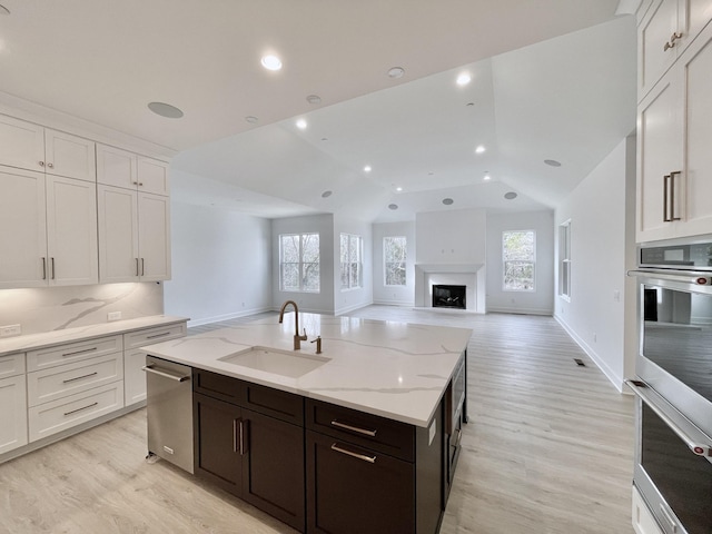 kitchen with tasteful backsplash, dark brown cabinetry, sink, and white cabinets