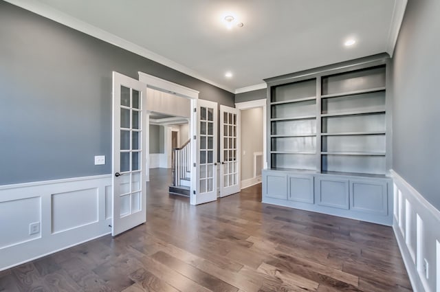 spare room with built in shelves, dark hardwood / wood-style floors, crown molding, and french doors