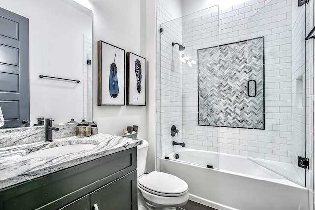 full bathroom featuring tiled shower / bath, vanity, and toilet