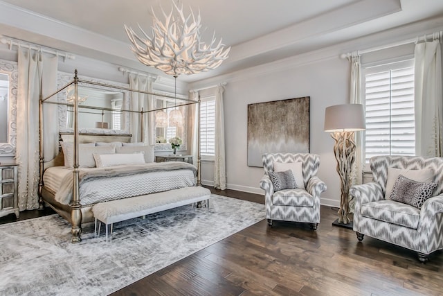 bedroom with a chandelier, ornamental molding, dark hardwood / wood-style flooring, and a raised ceiling