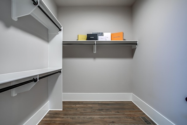 spacious closet with dark wood-type flooring