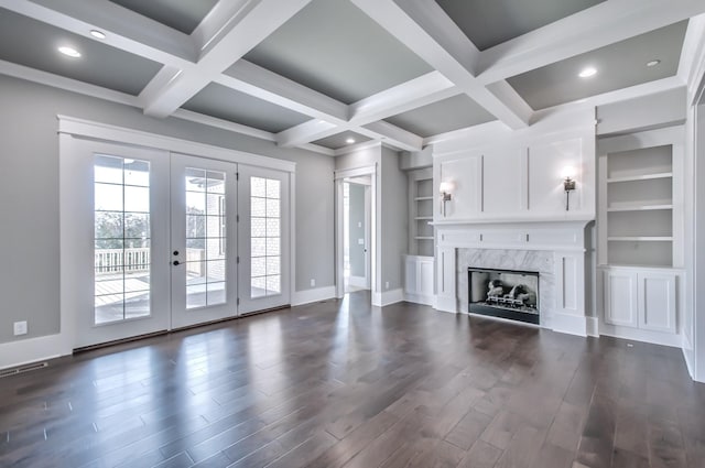 unfurnished living room with french doors, dark hardwood / wood-style floors, a premium fireplace, and built in features