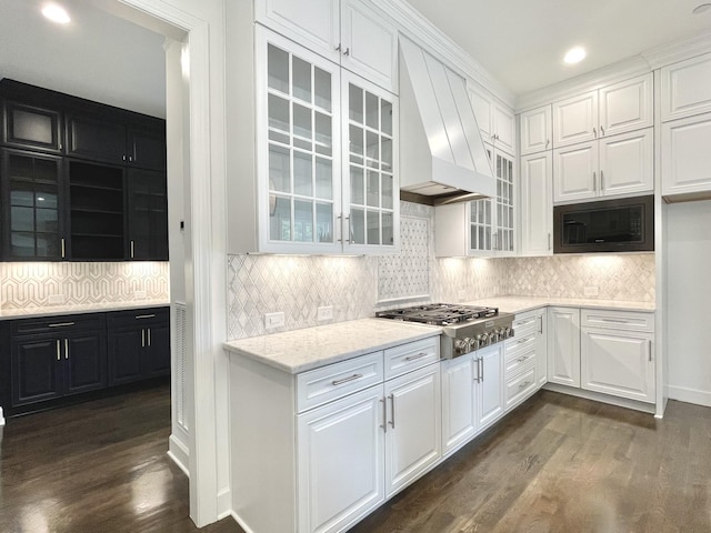 kitchen with white cabinetry, stainless steel gas stovetop, custom range hood, and black microwave